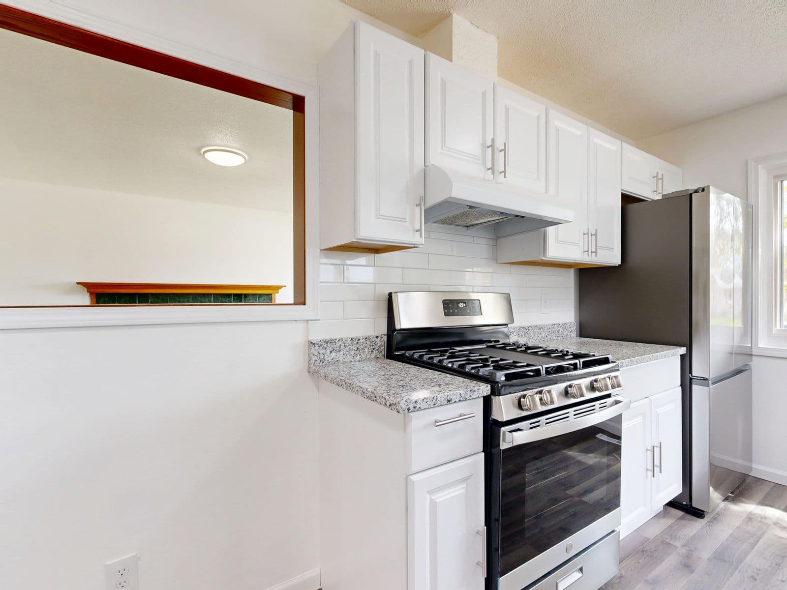 Bright modern kitchen with white cabinets and stainless steel appliances