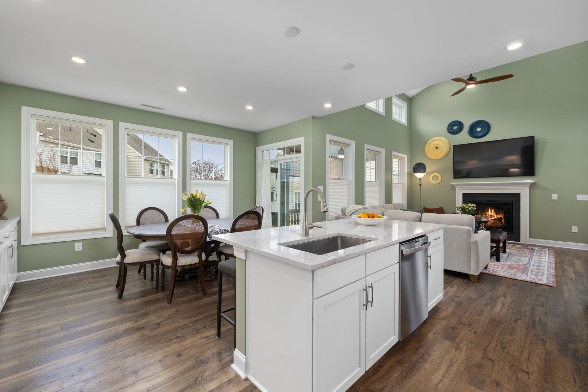 Bright open-concept kitchen and living room in a Canadian home, with hardwood floors and a fireplace