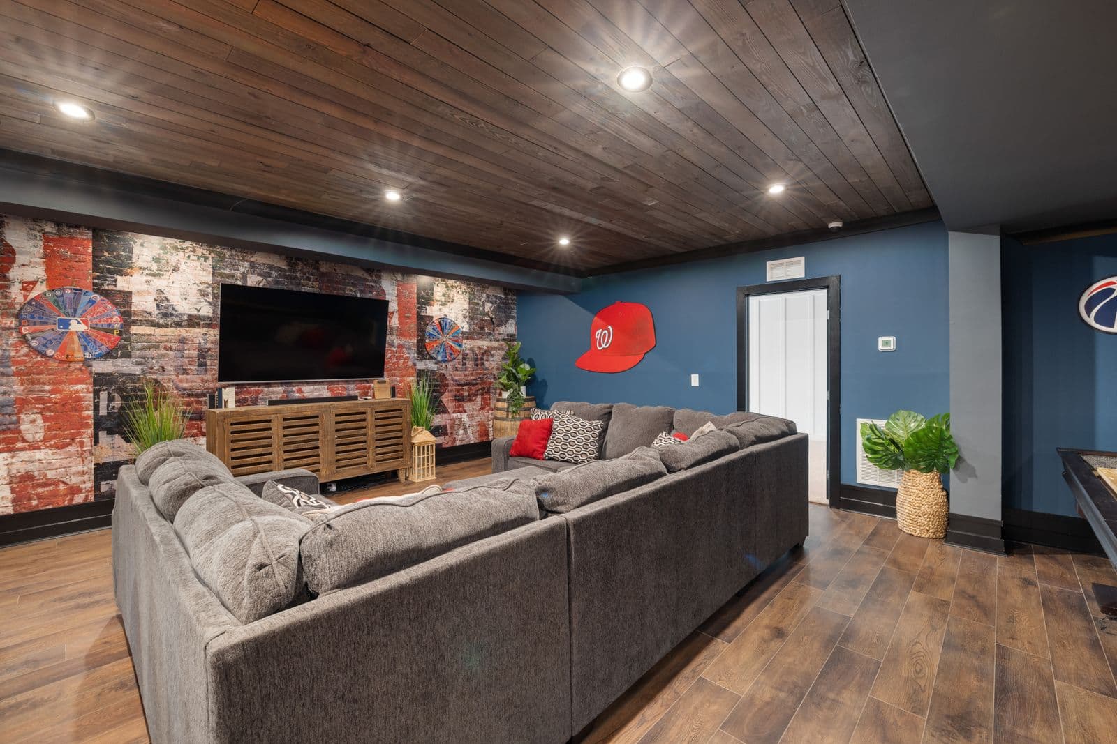 Finished basement recreation room with modern seating and TV setup