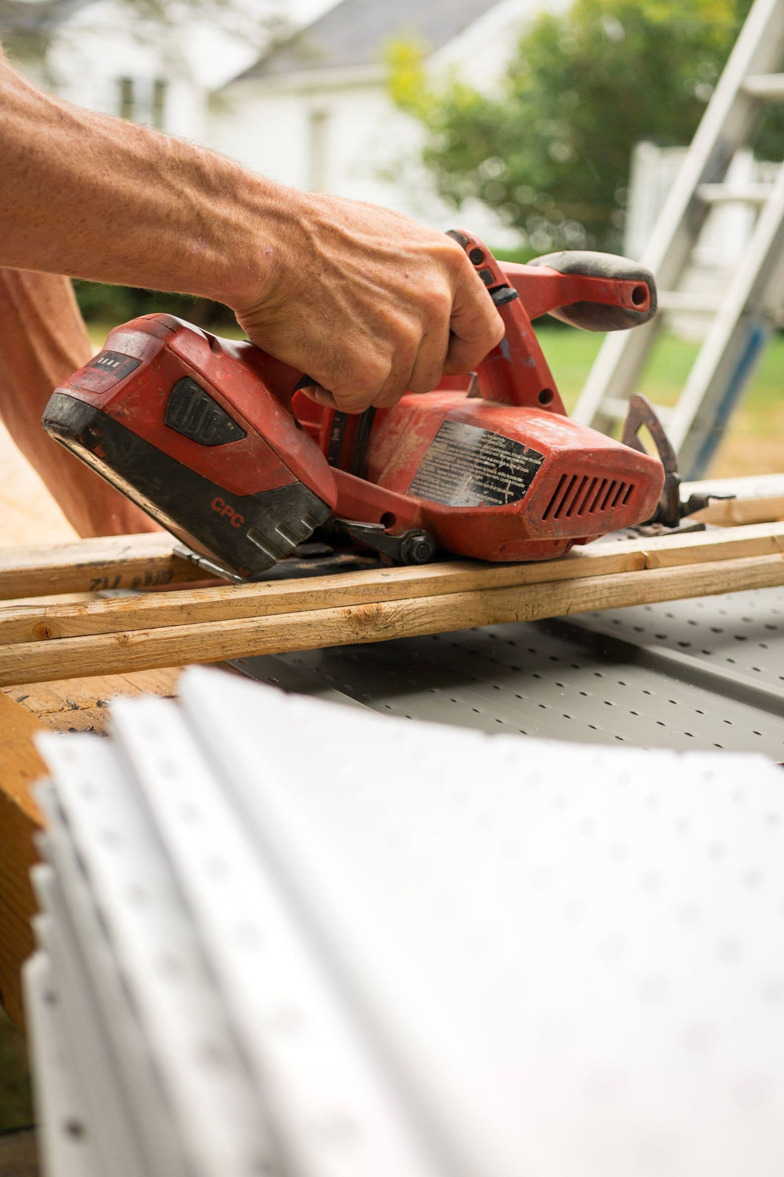 Close-up of a carpenter's hands sanding wood outdoors with precision
